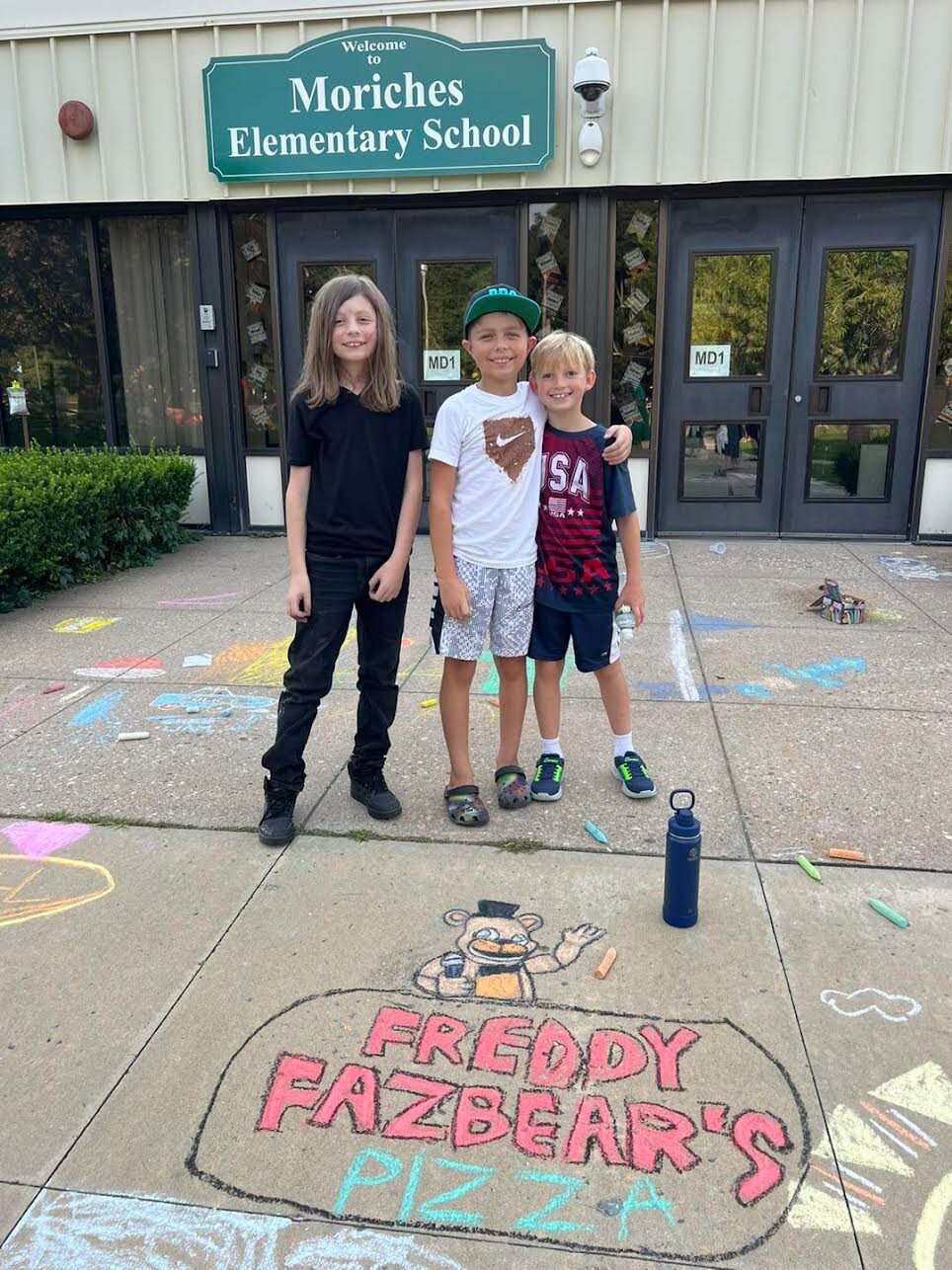 Students at Moriches Elementary School participate in “Chalk the Walk,” an annual tradition sponsored by the Moriches Elementary PTO, in which students, faculty, and staff come to the school the evening before school begins to write positive messages and draw colorful pictures in front of the building.